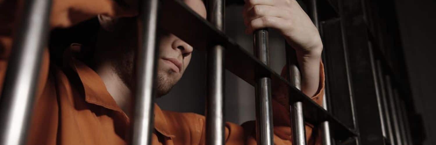 man holding jail bars