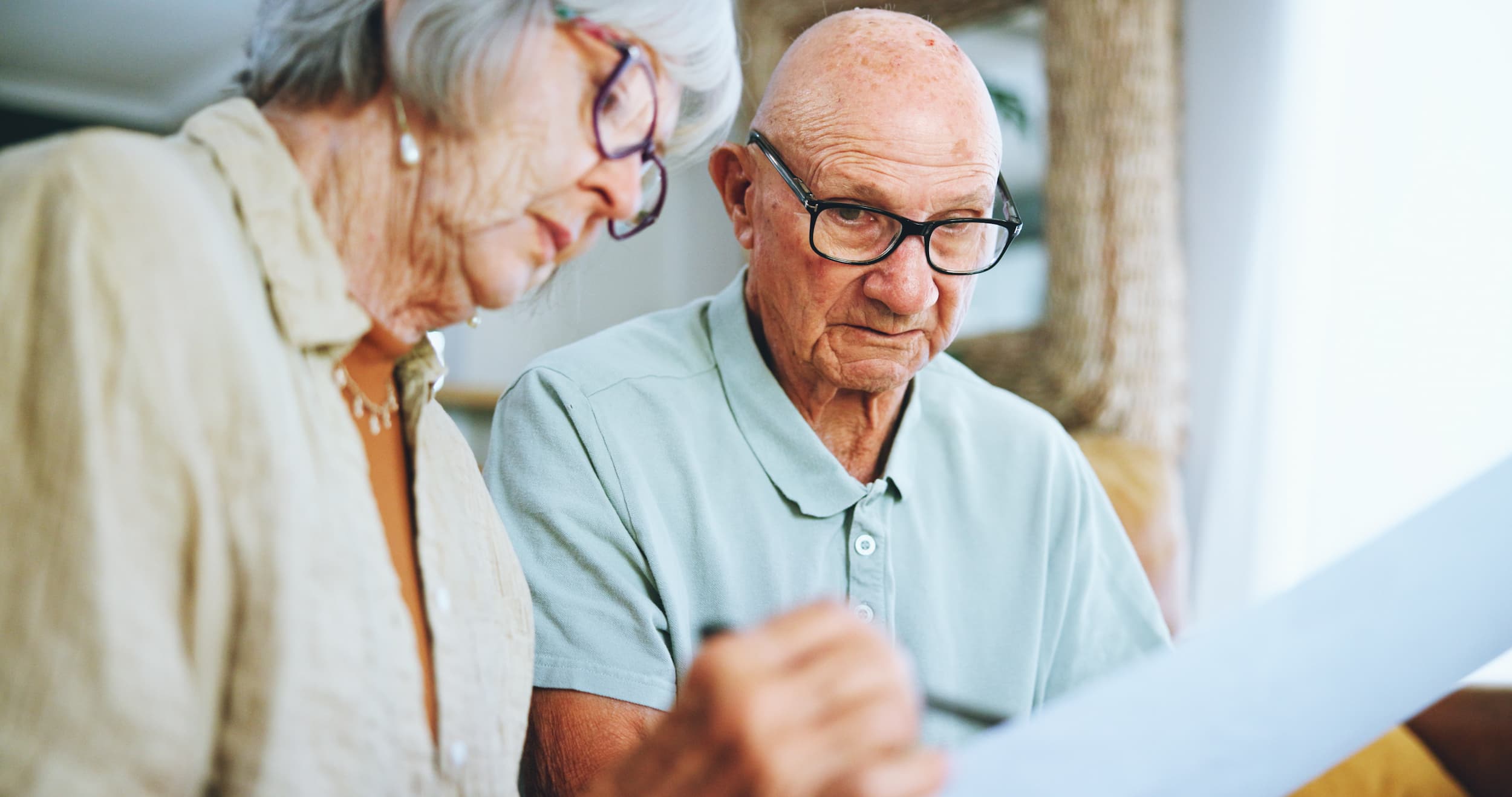 Senior couple reviewing legal documents at home.