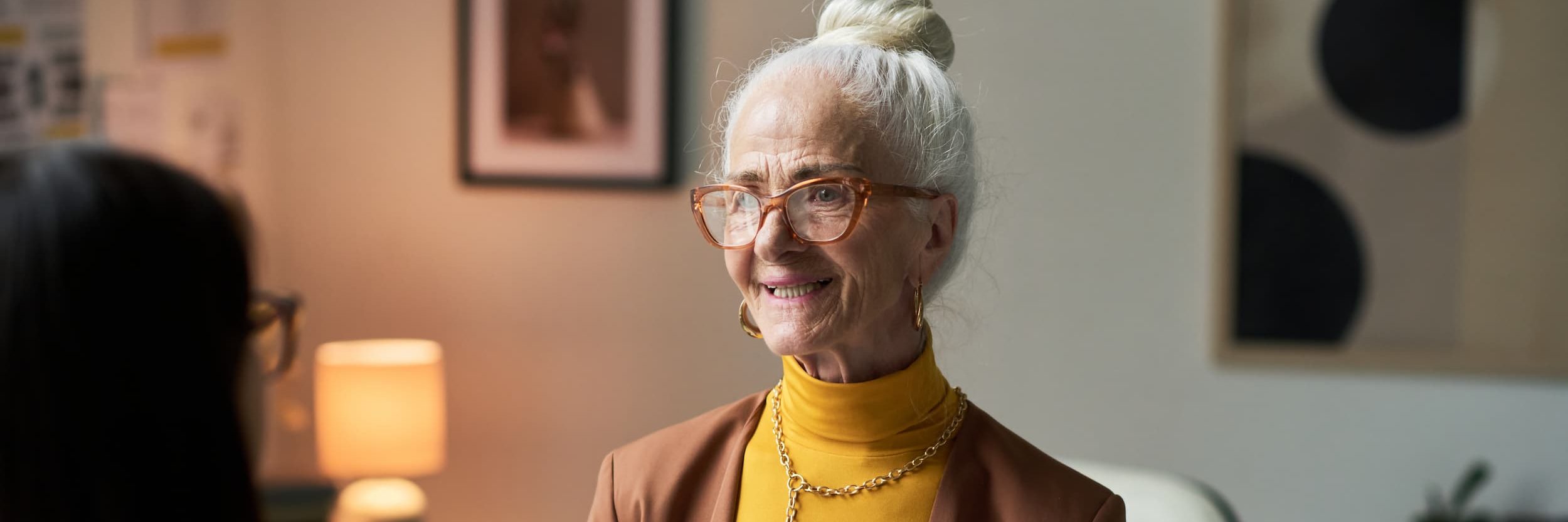 Smiling elderly woman holding legal documents during a consultation.