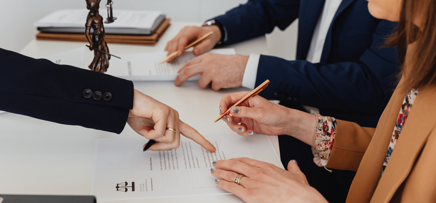 Couple signing separation documents with lawyer